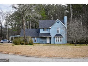 Charming two-story home featuring a classic blue exterior, complemented by a dark roof and a neatly maintained front yard at 3281 Nina Way, Douglasville, GA 30135