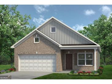 Charming brick home with a two-car garage, complemented by a well-manicured lawn and colorful flowers at 1492 Trellis Court (Lot 44), Hampton, GA 30228