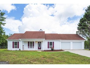 Charming single-story home with a well-manicured lawn, red shutters, and a covered front porch at 153 Cedar Ridge Rd, Locust Grove, GA 30248