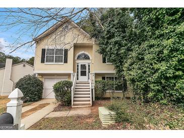 Charming two-story home featuring a welcoming entrance, well-kept lawn, and attached one car garage at 5827 Highgrove Dr, Atlanta, GA 30349