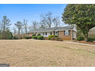 Charming one-story brick home with a covered front porch and mature landscaping, creating an inviting curb appeal at 3411 Airline Rd, Mcdonough, GA 30252