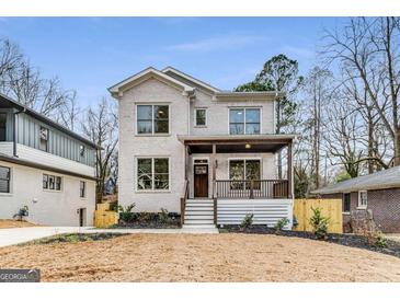 Two-story house with white brick, wood porch, and manicured landscaping at 1055 Ormewood Se Ave, Atlanta, GA 30316