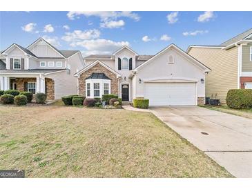 Charming two-story home with a stone facade, well-manicured lawn, and two car garage at 7764 Parkside Dr, Lithia Springs, GA 30122