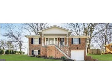 Charming brick home featuring a covered front porch and well-maintained landscaping at 3174 Kingston Nw Rd, Atlanta, GA 30318