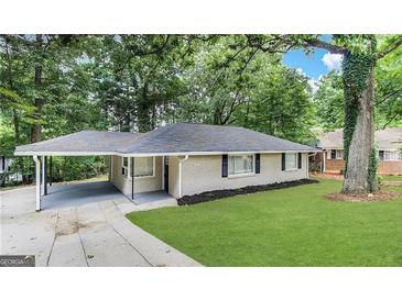 Charming ranch home with a lush lawn, carport, and mature trees surrounding the property at 1761 Carter Cir, East Point, GA 30344