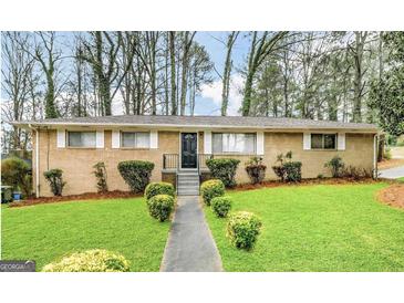 Charming brick home featuring a well-maintained front yard with lush green grass and manicured shrubbery at 2537 Bonnybrook Sw Dr, Atlanta, GA 30311