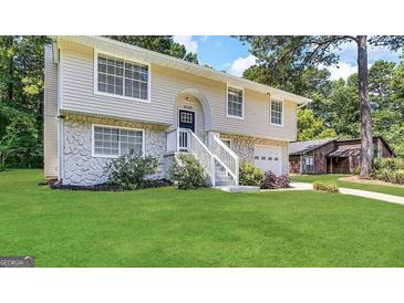 Two-story home with a stone facade and a well-maintained lawn, surrounded by lush trees and greenery at 4305 Old Lake Dr, Decatur, GA 30034