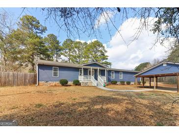 Charming single-story home with blue siding, white trim, inviting porch, and adjacent carport on a sunny day at 3345 S Highway 29, Moreland, GA 30259