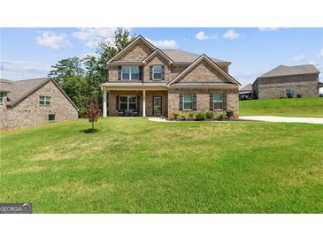 Charming brick home with a manicured lawn and inviting covered front porch at 121 Amelia Way, Ellenwood, GA 30294