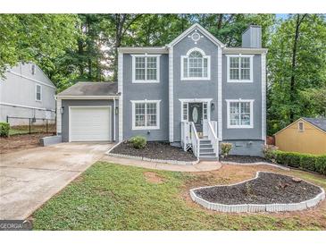 Charming two-story home with attached garage, well-manicured lawn, and gray paint at 2986 Cascade Manor Dr, Decatur, GA 30034