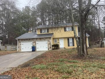 Charming two-story home features a stone-accented garage and a well-maintained front yard at 2400 Reynolds Sw Rd, South Fulton, GA 30331