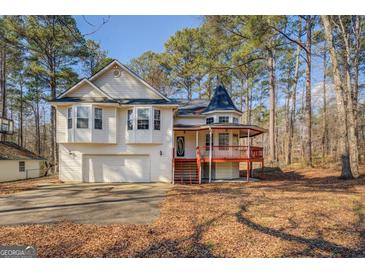 Charming two-story home with unique turret, front porch, and attached two car garage at 787 N Ola Rd, Mcdonough, GA 30252