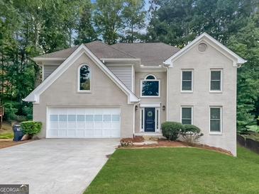 Charming two-story brick home with a well-manicured lawn and attached two-car garage at 925 Whitehawk Trl, Lawrenceville, GA 30043