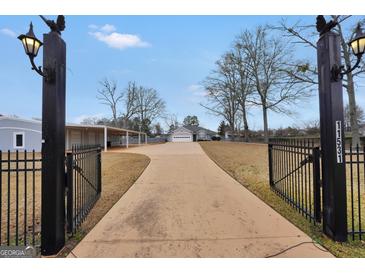 Long driveway leading to a well-maintained home with a convenient carport and an inviting curb appeal at 11531 E Lovejoy Rd, Hampton, GA 30228