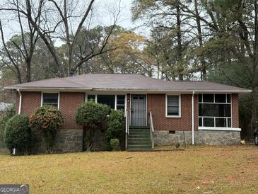 Charming single story brick home with stone foundation and landscaped front yard at 392 Carey Se Dr, Atlanta, GA 30315