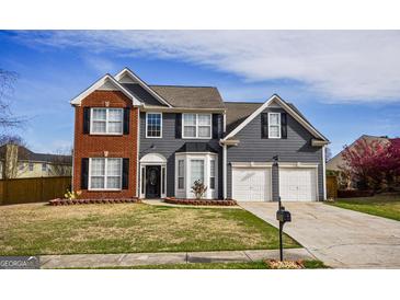 Charming two-story home with a brick and gray siding exterior, two-car garage, and well-maintained lawn at 3028 Hallman Cir, Marietta, GA 30064