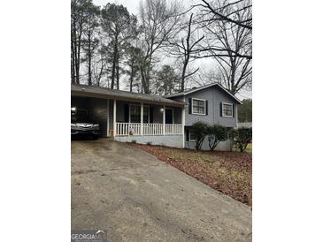 Charming home featuring a welcoming front porch and a convenient carport at 9055 Kelly Ct, Jonesboro, GA 30236