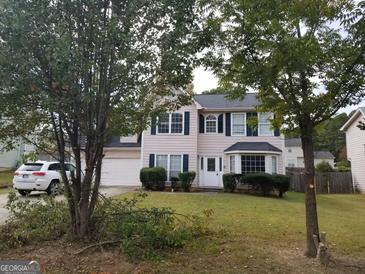 Charming two-story home features a well-manicured lawn, dark shutters, and a bright, welcoming white front door at 8495 Glendevon Ct, Riverdale, GA 30274