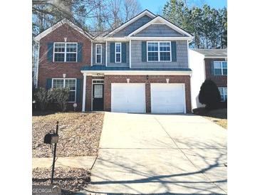 Charming two-story home featuring a brick and gray shingle facade, a well-maintained lawn, and a two-car garage at 1870 Wildcat Trace Cir, Lawrenceville, GA 30043