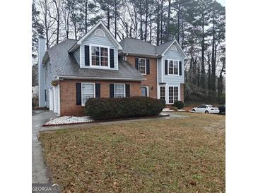 Charming two-story brick home featuring light blue accents, black shutters, and a well-maintained front yard at 10020 Crystal Ter, Jonesboro, GA 30238