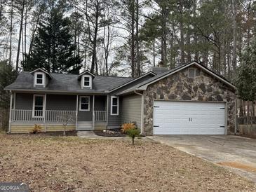 Charming home with gray siding, stone accents, dormer windows and an attached two-car garage at 115 Paces Way, Fayetteville, GA 30215