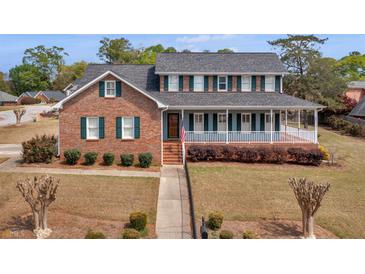 Two-story brick home with a large, welcoming front porch and well-maintained landscaping at 135 Oakpark Ter, Mcdonough, GA 30253