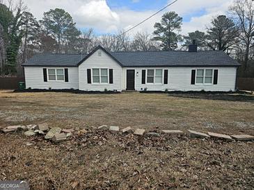 Charming single-story home featuring white siding, black shutters, and well-maintained landscaping at 3930 W Side Pl, Ellenwood, GA 30294