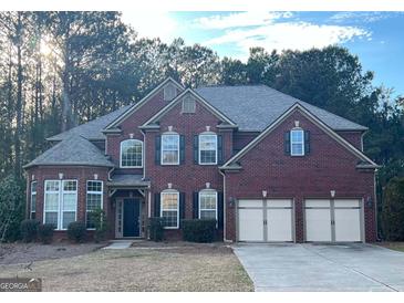 Charming two-story brick home with a three-car garage and mature landscaping in a quiet neighborhood at 100 Windmeadow Way, Fayetteville, GA 30214