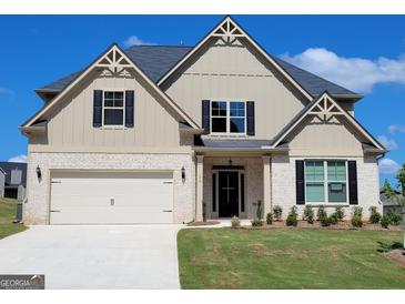 Charming two-story home with a two-car garage, white brick accents, and a well-manicured lawn at 175 Osier Dr, Mcdonough, GA 30252