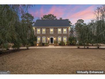 Charming brick home with classic architecture, a well-manicured lawn, and mature trees at 256 Allie Dr, Mcdonough, GA 30252