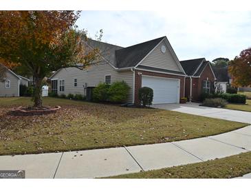 Charming single-Gathering home featuring a two-car garage and a well-maintained front lawn with a tree showing beautiful fall colors at 410 Mockingbird Dr, Loganville, GA 30052