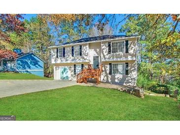 Two-story home featuring a wooden porch, attached garage, and lush green lawn at 5743 Rock Rd, Union City, GA 30291