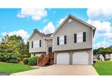 Charming two-story home with a well-maintained lawn, attached two-car garage, and inviting front entrance at 1202 Grove Trail Pass, Douglasville, GA 30134