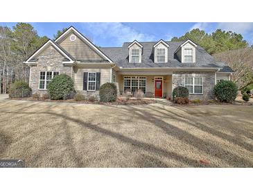 Charming single-Gathering home with stone accents, three dormer windows, and a bright red front door at 115 Foxford Run, Tyrone, GA 30290