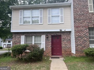 Charming townhome with brick and siding, featuring white shutters and a red front door at 923 Regal Path Ln, Decatur, GA 30030
