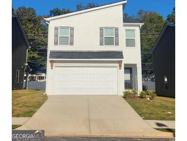 Modern two-story home with a clean white brick facade, a two-car garage, and neutral-tone accents at 4852 Station Lane # 19, Union City, GA 30349