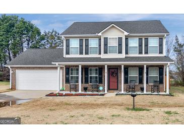 Charming two-story brick home with black shutters and a welcoming front porch at 141 Whistle Way, Locust Grove, GA 30248