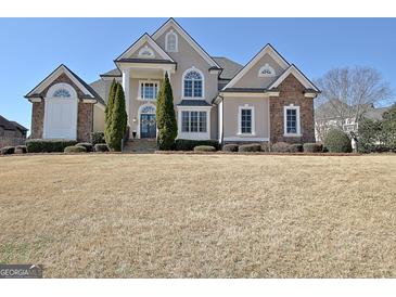 Stately home with a large front yard, stone and stucco facade, and architectural details at 550 Wentworth Ct, Fayetteville, GA 30215