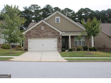 Charming one-story home featuring a brick facade, attached two-car garage, and manicured front lawn at 2297 Knob Creek Dr, Snellville, GA 30078