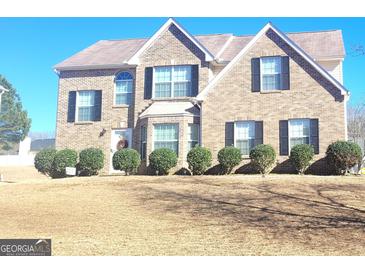 Beautiful brick two-story home with well-manicured bushes, a bay window, and a front door wreath at 11714 Double Lake Xing, Fayetteville, GA 30215