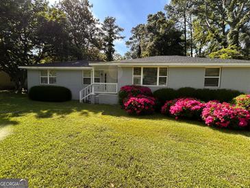 Charming single-story home with a well-manicured lawn and vibrant azalea bushes at 47 Elm St, Hampton, GA 30228