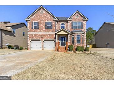 Beautiful two-story brick home with attached two car garage and manicured front yard at 536 Caledon Way, Hampton, GA 30228