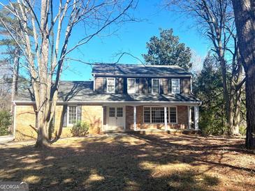 Charming two-story brick home with a welcoming front porch and well-manicured landscaping at 6740 Davidson Ct, Lithonia, GA 30058