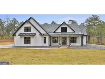 Stunning modern farmhouse with black accents, a manicured lawn, and a welcoming front porch at 285 Hogan Coweta Rd, Hogansville, GA 30230