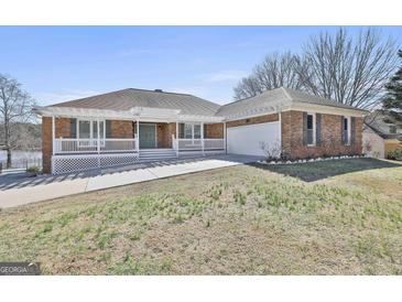 Charming brick home with white pergola, covered porch and nicely manicured lawn at 205 Castlewood Rd, Tyrone, GA 30290