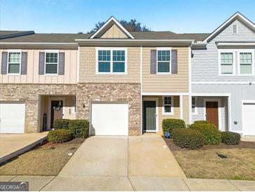 Charming exterior of a two-story townhome with a one-car garage and small front yard at 3232 Tarian Way, Decatur, GA 30034