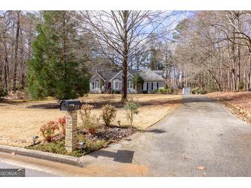 Charming home with a well-maintained front yard, a lovely blend of trees, and a long driveway at 120 Wisteria Ct, Tyrone, GA 30290