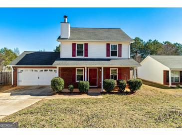 Charming two-story home with a well-maintained front yard, brick accents, and a two-car garage at 261 Whistle Way, Locust Grove, GA 30248