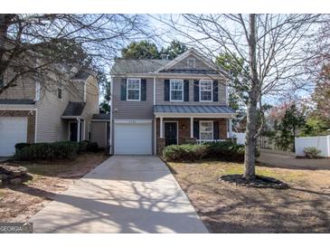 Charming two-story home with gray siding, black shutters, covered porch, and a well-manicured front yard at 5790 Ridge Stone Way, Cumming, GA 30041