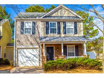 Charming two-story home with stone accents, attached garage and manicured landscaping at 5790 Ridge Stone Way, Cumming, GA 30041